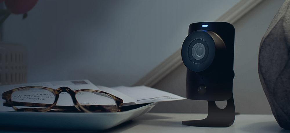 security camera next to papers and glasses on a table