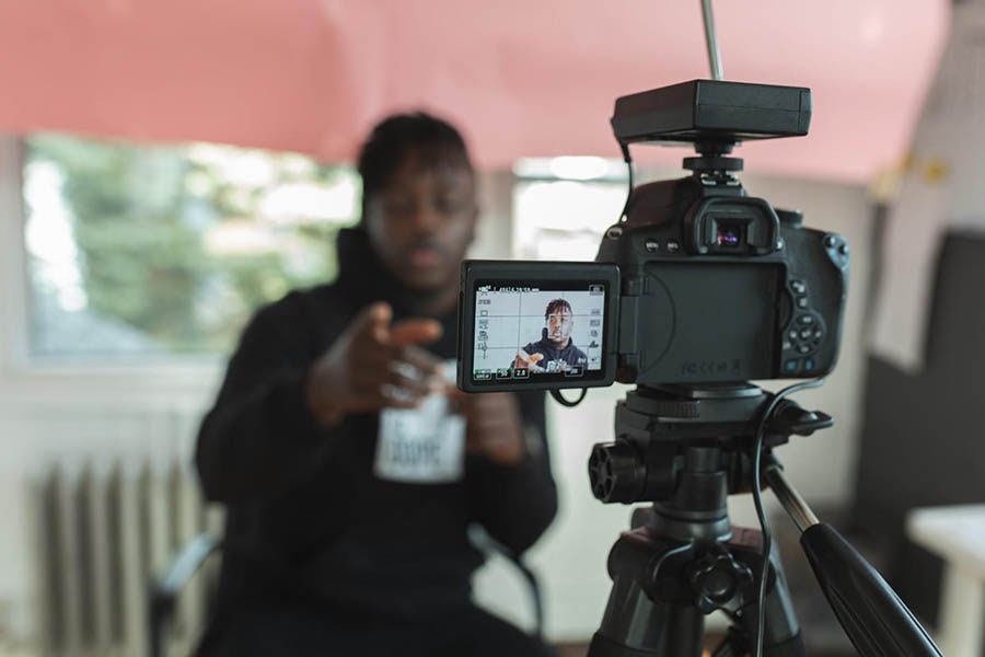 Young man recording himself on a video camera.