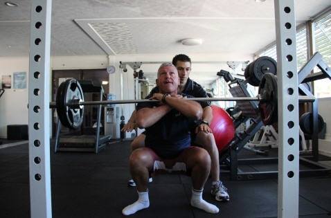 A Personal Trainer assisting a client.